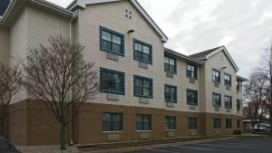 een groot bakstenen gebouw met een boom ervoor bij Suburban Studios Minneapolis Bloomington in Bloomington