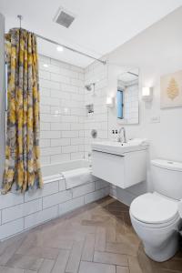 芝加哥的住宿－Luxe SFH in the Heart of Old Town，浴室配有卫生间、浴缸和水槽。