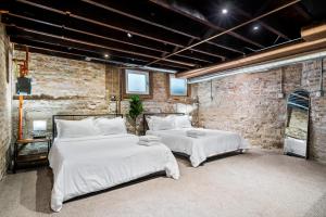 a bedroom with two beds and a brick wall at Luxe SFH in the Heart of Old Town in Chicago