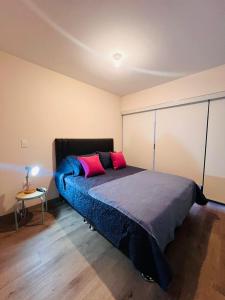 1 dormitorio con 1 cama con 2 almohadas rosas en M2 #13 - DPTO 2 dorm - Frente Embajada USA, en Lima