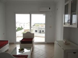 a living room with a large window and a table at Residence Sterne in Ḩammām al Ghazzāz