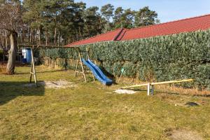 einen Spielplatz mit Rutsche vor der Wand in der Unterkunft Ferienbungalows Freest in Freest