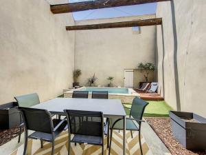un patio con mesa, sillas y piscina en La casita - Maison cocooning avec piscine, en Canet d'Aude