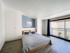 1 dormitorio con cama grande y ventana grande en La casita - Maison cocooning avec piscine, en Canet d'Aude