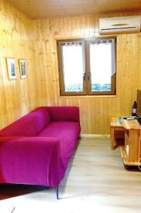 ein Wohnzimmer mit einem lila Sofa und einem Tisch in der Unterkunft Chalet de Santa in Corte