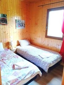 ein Schlafzimmer mit zwei Betten und einem Fenster in der Unterkunft Chalet de Santa in Corte