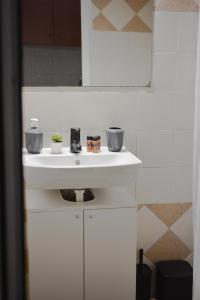 bagno con lavandino bianco e specchio di Daphne's studio 1 a Città di Skiathos