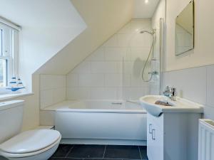 a white bathroom with a sink and a toilet at 4 Bed in Tenby FB270 in Tenby