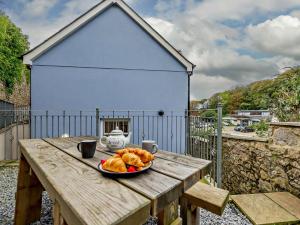 a plate of bread on a wooden table in front of a house at 4 Bed in Tenby FB270 in Tenby