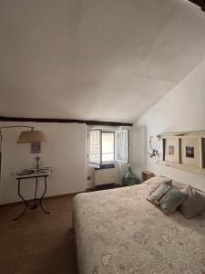 Schlafzimmer mit einem Bett, einem Tisch und einem Fenster in der Unterkunft Trentapassidairolli in Genua