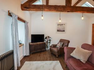 a living room with a couch and a tv at The Old Parlour in Rhyl