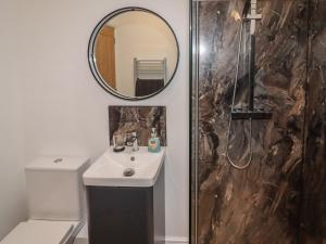a bathroom with a sink and a mirror at The Old Parlour in Rhyl +15 photos