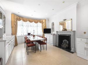 a kitchen with a table and chairs and a fireplace at Large 5 Bedroom house in Finchley in Maida Vale
