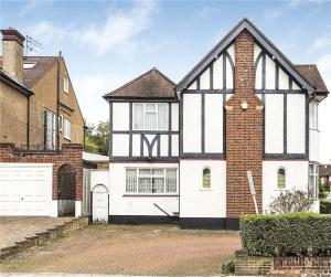 a large black and white house with a garage at Large 5 Bedroom house in Finchley in Maida Vale