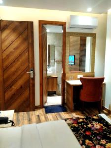 a bathroom with a desk and a door with a mirror at HOTEL RV GOLDEN in Amritsar