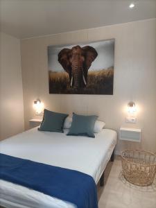 a bedroom with an elephant painting on the wall at Camping Relax Sol in Torredembarra