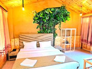 a bedroom with a bed with a plant above it at Hotel Old Manali with Balcony and Mountain Views, Near Manali Mall Road in Manāli