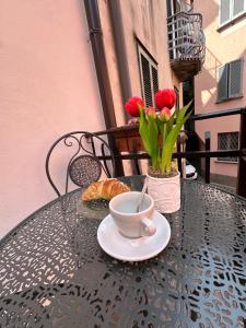 a table with a cup of coffee and flowers on it at THE ALLEY 7 in Malgrate