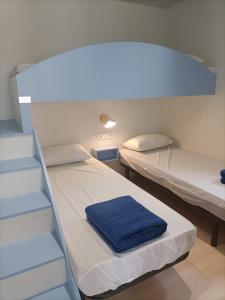 Habitación pequeña con 2 camas y escalera. en Camping Relax Sol, en Torredembarra