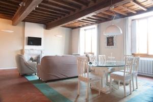 ein Wohnzimmer mit einem Tisch, Stühlen und einem Sofa in der Unterkunft Tornabuoni Charming Apartment in Florenz