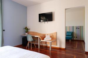 - une chambre avec un bureau, une chaise et une télévision dans l'établissement HA Hotel, à Bracciano