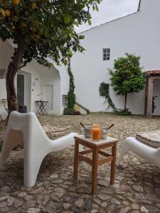 uma mesa com duas cadeiras e uma mesa com bebidas em Casa Pátio do Megué em Évora