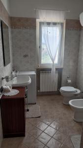 ein Bad mit einem Waschbecken, einem WC und einem Fenster in der Unterkunft Dimora da Capo Appartamento in Villa in Casoli