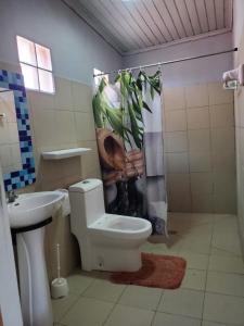 a bathroom with a toilet and a shower curtain at Bungalow chez Mouch Nosy-Be 4 in Nosy Be