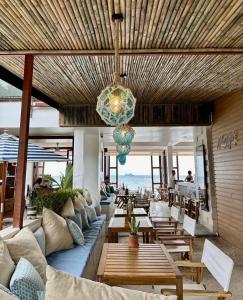 a living room with a couch and tables and a chandelier at Blue Tao Beach Hotel - SHA Plus in Ko Tao