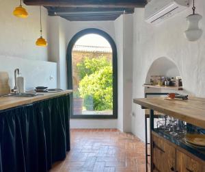 a kitchen with an arched window and a kitchen counter at CORNER NEST IN MONTALCINO in Montalcino