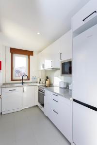 cocina blanca con electrodomésticos blancos y ventana en Arts Garden, en Oporto