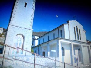 a white church with a tower with a fence around it at B&B da Gi&Jo in Forgaria nel Friuli