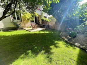 a backyard with a lawn with a picnic table in it at Appartement Cosy avec Jardin in Saint-Cloud