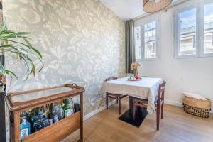 a dining room with a table with a white table cloth at Appartement Cosy avec Jardin in Saint-Cloud