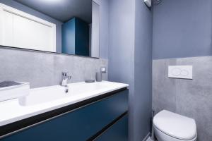 Un baño con lavabo, inodoro y espejo. en Garda Marina by Garda FeWo, en Manerba del Garda