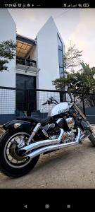 een zwarte motorfiets geparkeerd voor een huis bij Rumah Kembar DI kawasan wisata lembang in Citeureup 1