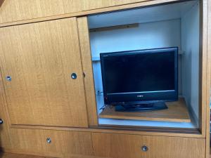 a tv sitting inside of a cabinet with a mirror at Duplex de la République in Millau