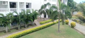 an image of a palm tree in front of a building at Becky Homes Diani Beach - 2BR with AC & Pool in Diani Beach