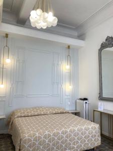 1 dormitorio con cama y espejo en la pared en Hotel Cresp en Niza