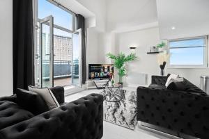 a living room with a couch and a large window at Duplex Penthouse Apartment - Birmingham City Centre - Secure Parking - Terrace 1401M in Birmingham