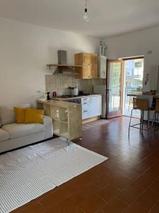 ein Wohnzimmer mit einem weißen Sofa und einer Küche in der Unterkunft Appartamento Gaia - a due passi dal centro in Laveno-Mombello