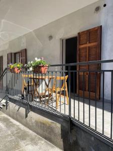 einen Balkon mit 2 Stühlen und einem Tisch mit Blumen in der Unterkunft Appartamento Gaia - a due passi dal centro in Laveno-Mombello