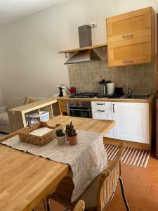 eine Küche mit einem Holztisch und eine Küche mit einem Herd in der Unterkunft Appartamento Gaia - a due passi dal centro in Laveno-Mombello