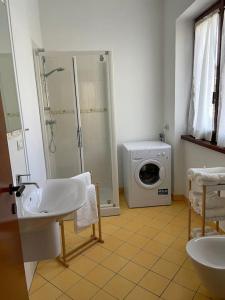 a bathroom with a sink and a washing machine at Appartamento Gaia - a due passi dal centro in Laveno-Mombello
