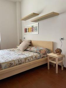 sypialnia z łóżkiem i stolikiem nocnym ze stołem w obiekcie Appartamento Gaia - a due passi dal centro w mieście Laveno-Mombello