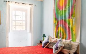 a bedroom with a colorful curtain and a bed with pillows at 9Arches in Vila Nova de Poiares
