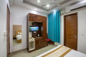 a bedroom with a bed and a television in a room at Hotel Surya Palace By Aura in Noida