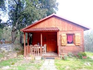 a small cabin with a porch in a field at Chalet de Santa in Corte