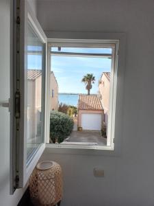 een raam in een kamer met uitzicht op de oceaan bij Maison Gruissan Mateille in Gruissan