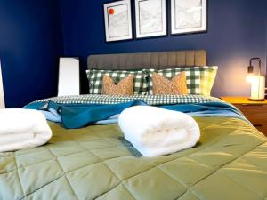 a blue bedroom with a large bed with white pillows at Cwtch Corner By MGroup SA in Treherbert
